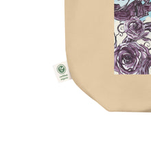 Load image into Gallery viewer, close up of tag, showing certified organic, oyster colored tote bag, certified organic. Image design: Design: Watercolor raven and roses, with a light blue and white watercolor background and shooting stars print behind the image
