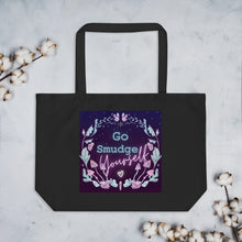 Load image into Gallery viewer, large black tote bag, certified organic, tote bag. Image design: whimsical mushrooms with eyes, crystals, with text, &quot;Go smudge yourself.&quot;
