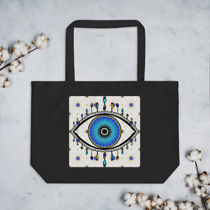 large black colored tote bag with image of eye of protection/evil eye, colors of golden yellow, blue, light blue, third eye, eye, celestial stars. certified organic, cotton.