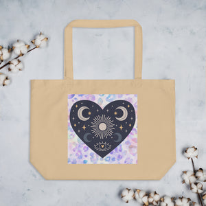 large oyster colored tote bag, certified organic. Image design: blue mystical heart with eye in middle, and crescent moons, and a light purple leopard print background behind the image