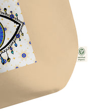 Load image into Gallery viewer, close up image of tag showing certified organic, large oyster colored tote bag with image of eye of protection/evil eye, colors of golden yellow, blue, light blue, third eye, eye, celestial stars. certified organic, cotton.
