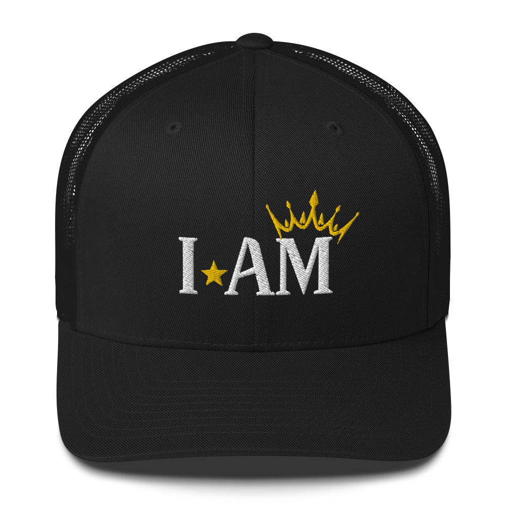 retro trucker hat black, with image phrase: "I AM," with image graphic of a gold crown over the letter M. Front view.