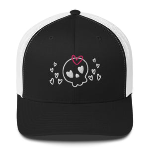 retro trucker hat/cap black white, with image design of a cartoonish cute skull with heart eyes, a heart bow, and stars. Front view.