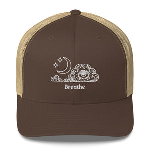 retro trucker hat/cap brown khaki , with image design of an eye in a cloud, with moon crescent and stars, with the word "Breathe" underneath the image.  Front view.