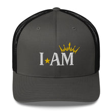 Load image into Gallery viewer, retro trucker hat charcoal grey black, with image phrase: &quot;I AM,&quot; with image graphic of a gold crown over the letter M. Front view.
