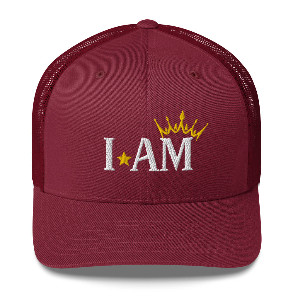 retro trucker hat cranberry red, with image phrase: "I AM," with image graphic of a gold crown over the letter M. Front view.