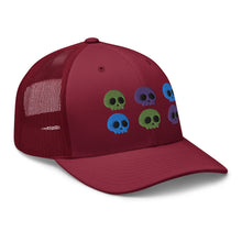 Load image into Gallery viewer, retro trucker hat cranberry red, with image design of 6 purple, green, and blue skulls, 2 of each color, in two rows.  side view.
