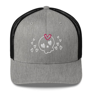 retro trucker hat/cap heather black, with image design of a cartoonish cute skull with heart eyes, a heart bow, and stars. Front view.