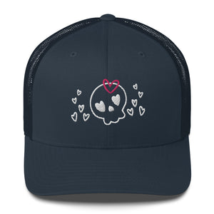 retro trucker hat/cap navy blue , with image design of a cartoonish cute skull with heart eyes, a heart bow, and stars. Front view.