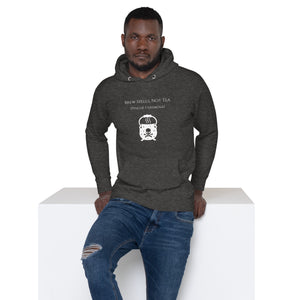 Man modeling/wearing Unisex charcoal grey heather hoodie with image phrase: "Brew spells, not tea (pinche chismosa)." Underneath words is an image of a cauldron decorated with stars and skull with crossbones. Front view. Halloween, spooky season.