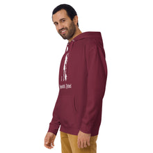 Load image into Gallery viewer, Man modeling/ wearing maroon unisex hoodie, with pockets. Image design: silhouette of a pretty witch holding a magical broom, stars. Image phrase: Broomstick rebel. Front view.
