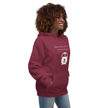 Load image into Gallery viewer, Woman modeling/wearing Unisex maroon hoodie with image phrase: &quot;Brew spells, not tea (pinche chismosa).&quot; Underneath words is an image of a cauldron decorated with stars and skull with crossbones. Front view. Halloween, spooky season.
