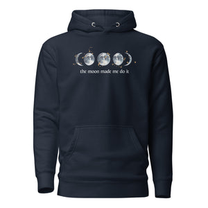 unisex navy blue hoodie with image phrase "The moon made me do it." With image graphic of watercolor moon phases, decorated with random gold star constellations. Front view.