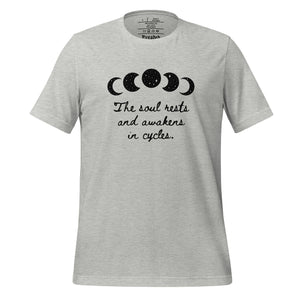 unisex heather grey t-shirt, with image of black celestial moon phases, with star cut outs, and image phrase "The soul rests and awakens in cycles." Front view.