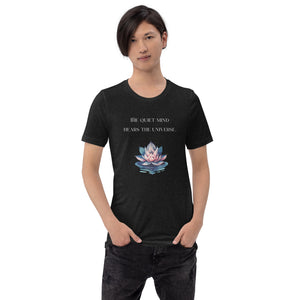 man modeling/wearing unisex black heather t-shirt, with image phrase: "The quiet mind hears the Universe." Image of watercolor pink and blue lotus flower floating on water.