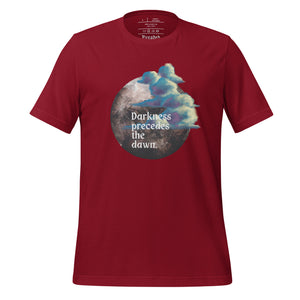 unisex cardinal red t-shirt with image design of a dark moon, with a colorful dawn cloud in front, with image phrase: "Darkness precedes the Dawn." Front View.