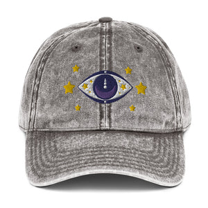 vintage denim cap charcoal grey, with image design of blue eye of protection/evil eye/third eye, with stars. Front view.