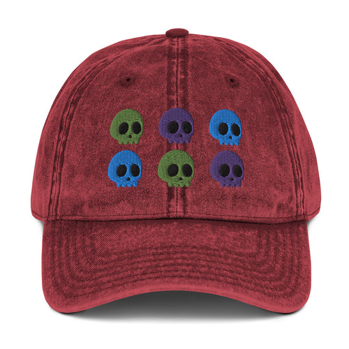 vintage denim cap maroon, with image design of 6 purple, green, and blue skulls, 2 of each color, in two rows.  Front view.