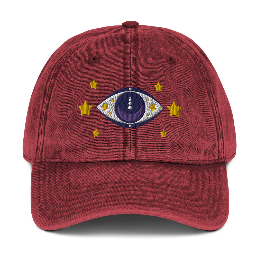 vintage denim cap maroon, with image design of blue eye of protection/evil eye/third eye, with stars. Front view.