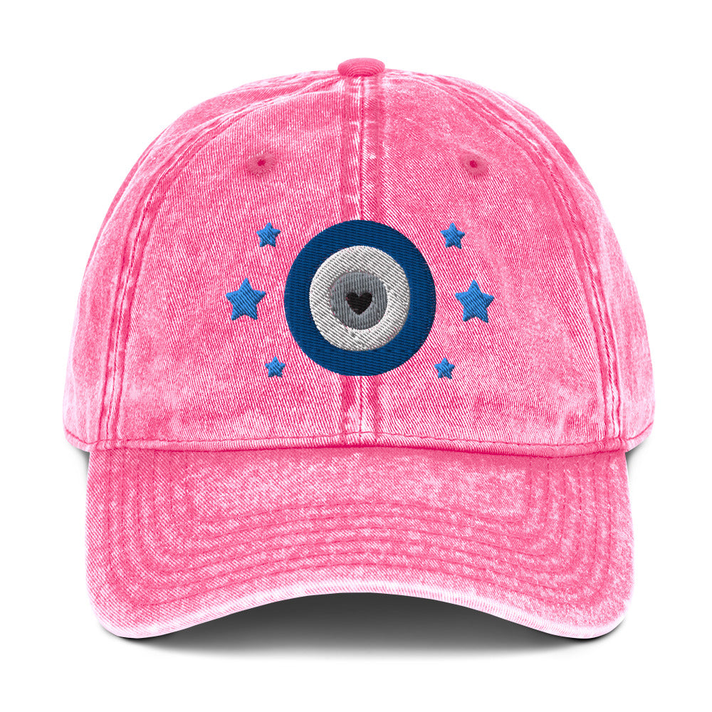 vintage denim cap pink, with image design of blue eye of protection/evil eye/third eye, with stars. Front view.