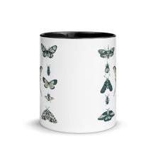 Load image into Gallery viewer, 11 oz. white ceramic coffee/tea mug with solid black handle, rim, and inside. Image Design:  vintage beige and blue print images of various moths, butterflies, and beetles, all arranged in rows and columns. Center front view. Halloween, spooky season.
