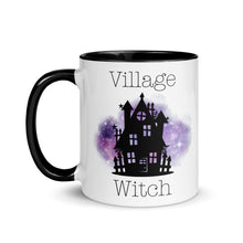 Load image into Gallery viewer, 11 oz. white ceramic coffee/tea mug with solid black handle, rim, and inside. Image Design: silhouette of black haunted house, cosmic purple cloud in background. Image phrase: Village witch. Left hand side view. Halloween, spooky season.
