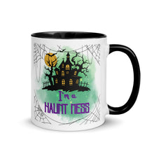 Load image into Gallery viewer, 11 oz. white ceramic coffee/tea mug with solid black handle, rim, and inside. Image Design: a silhouette of a haunted house, with a moon behind it, and cosmic green cloud behind image. Spider webs in each corners of image. Image phrase: I&#39;m a Haunt Mess. Right hand side view. Halloween, spooky season.
