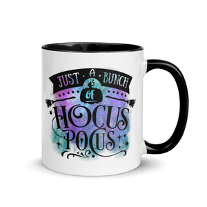 11 oz. white ceramic coffee/tea mug with solid black handle, rim, and inside. Image Design: phrase "just a bunch of Hocus Pocus, with mini image of pumpkin and broom,  whimsical font. backed by blue and purple cosmic cloud. Image phrase: Just a bunch of Hocus Pocus. Right hand side view. Halloween, spooky season.