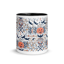 Load image into Gallery viewer, 11 oz. white ceramic coffee/tea mug with solid black handle, rim, and inside. Image Design: Halloween pattern of skull faces, crossbones, bats, pumpkins, fall leaves. center front view.
