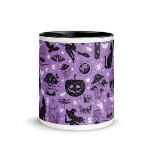 11 oz. white ceramic coffee/tea mug with solid black handle, rim, and inside. Image Design: Halloween theme pattern of witch on broom, pumpkins, spiders, cats, potion bottles, snails, bats, mushrooms, with a cosmic tone. Purple background color. Center front view. Halloween, spooky season.