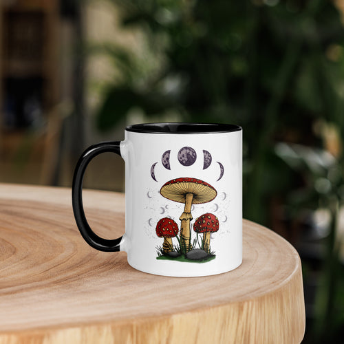 11 oz. white ceramic coffee/tea mug with solid black handle, rim, and inside. Image Design: Mushroom cluster, moon phases, and constellations. left hand side view.