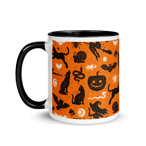 11 oz. white ceramic coffee/tea mug with solid black handle, rim, and inside. Image Design: Halloween theme pattern of witch's familiars, witch on broom, pumpkins, snakes, lizards, spiders, moon crescent, owls, cats, moths, background color is orange, with a cosmic tone. left hand side view. Halloween, spooky season.