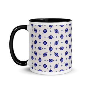 11 oz. white ceramic coffee/tea mug with solid black handle, rim, and inside. Wrapped around mug is patterned image of eye of protection/evil eye. Left hand side view.