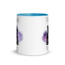 Load image into Gallery viewer, 11 oz. white ceramic coffee/tea mug with solid light blue handle, rim, and inside. Image Design: silhouette of black haunted house, cosmic purple cloud in background. Image phrase: Village witch. Center front view. Halloween, spooky season.
