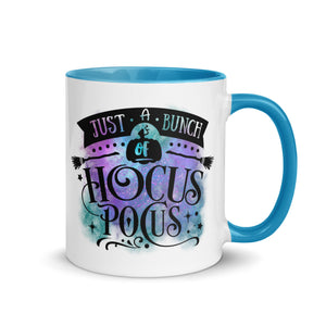 11 oz. white ceramic coffee/tea mug with solid light blue handle, rim, and inside. Image Design: phrase "just a bunch of Hocus Pocus, with mini image of pumpkin and broom,  whimsical font. backed by blue and purple cosmic cloud. Image phrase: Just a bunch of Hocus Pocus. right hand side view. Halloween, spooky season.