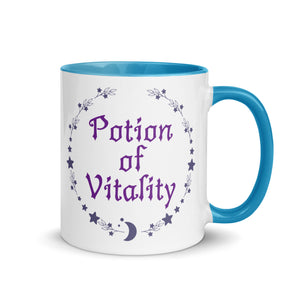 11 oz. white ceramic coffee/tea mug with solid light blue handle, rim, and inside. Image Design: Purple words 'Potion of Vitality' bordered by stars, leaves, and crescent moon at the bottom. Image phrase: Potion of Vitality. Right hand side view. Halloween, spooky season.