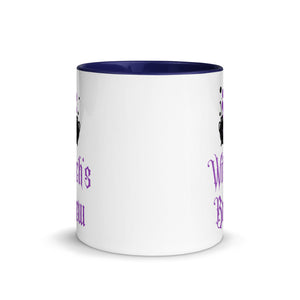 11 oz. white ceramic coffee/tea mug with solid navy blue handle, rim, and inside. Image Design: above image phrase, black cauldron with purple smoke, crescent moon on cauldron. Image phrase: Witch's brew. Center front view. Halloween, spooky season.