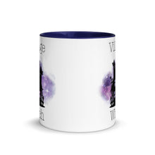 Load image into Gallery viewer, 11 oz. white ceramic coffee/tea mug with solid navy blue handle, rim, and inside. Image Design: silhouette of black haunted house, cosmic purple cloud in background. Image phrase: Village witch. Center front view. Halloween, spooky season.
