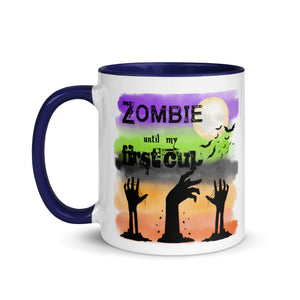 11 oz. white ceramic coffee/tea mug with solid navy blue handle, rim, and inside. Image Design: silhouette of zombie hands reaching out of ground, background colors orange, light orange, grey-black, light green, purple, moon and bats in background. Image phrase: Zombie until my first cup. left hand side view. Halloween, spooky season.