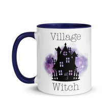 Load image into Gallery viewer, 11 oz. white ceramic coffee/tea mug with solid navy blue handle, rim, and inside. Image Design: silhouette of black haunted house, cosmic purple cloud in background. Image phrase: Village witch. Left hand side view. Halloween, spooky season.
