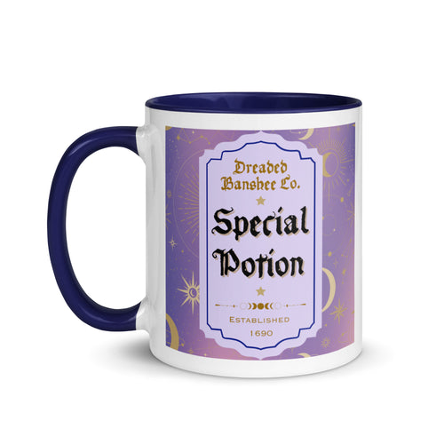 11 oz. white ceramic coffee/tea mug with solid navy blue handle, rim, and inside. Image Design: potion label that says 'Special Potion' with brand name above 'Dreaded Banshee Co., established 1690.' Purple-bluish background color with motif of suns, crescent moons, stars, constellations. Image phrase: Special Potion. Left hand side view. Halloween, spooky season.