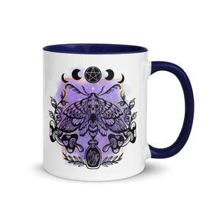 11 oz. white ceramic coffee/tea mug with solid navy blue handle, rim, and inside. Design: Moth with a skull, moon phases, pentacle, mushrooms, and a crystal vial. right hand side view.