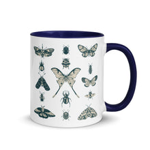 Load image into Gallery viewer, 11 oz. white ceramic coffee/tea mug with solid navy blue handle, rim, and inside. Image Design:  vintage beige and blue print images of various moths, butterflies, and beetles, all arranged in rows and columns. Right hand side view. Halloween, spooky season.
