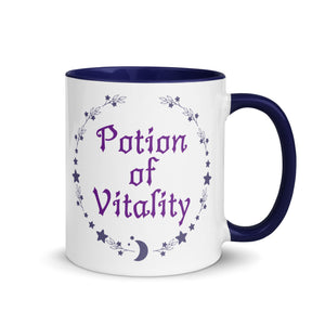 11 oz. white ceramic coffee/tea mug with solid navy blue handle, rim, and inside. Image Design: Purple words 'Potion of Vitality' bordered by stars, leaves, and crescent moon at the bottom. Image phrase: Potion of Vitality. Right hand side view. Halloween, spooky season.