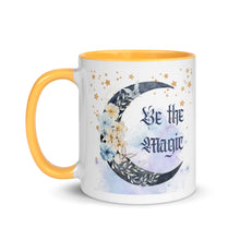 Load image into Gallery viewer, 11 oz. white ceramic coffee/tea mug with solid golden yellows handle, rim, and inside. Image Design: watercolor blue crescent moon, with flowers, daisies, lilies, butterflies. Stars in background, smoky purple background. Image phrase: Be the Magic. left hand side view. Halloween, spooky season.
