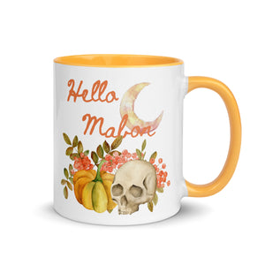 11 oz. white ceramic coffee/tea mug with solid golden yellow handle, rim, and inside. Image Design:  watercolor pumpkin, and skull, leaves and berries behind. Crescent moon in background. Image phrase: Hello Mabon. Right hand side view. Halloween, spooky season.