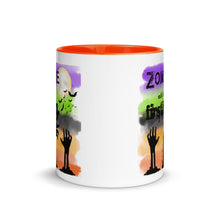 Load image into Gallery viewer, 11 oz. white ceramic coffee/tea mug with solid dark orange handle, rim, and inside. Image Design: silhouette of zombie hands reaching out of ground, background colors orange, light orange, grey-black, light green, purple, moon and bats in background. Image phrase: Zombie until my first cup. center front view. Halloween, spooky season.
