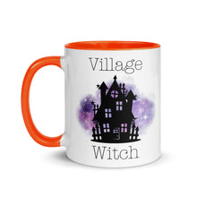 Load image into Gallery viewer, 11 oz. white ceramic coffee/tea mug with solid dark orange handle, rim, and inside. Image Design: silhouette of black haunted house, cosmic purple cloud in background. Image phrase: Village witch. Left hand side view. Halloween, spooky season.
