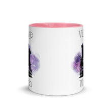 Load image into Gallery viewer, 11 oz. white ceramic coffee/tea mug with solid light pink handle, rim, and inside. Image Design: silhouette of black haunted house, cosmic purple cloud in background. Image phrase: Village witch. Center front view. Halloween, spooky season.
