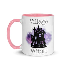 Load image into Gallery viewer, 11 oz. white ceramic coffee/tea mug with solid light pink handle, rim, and inside. Image Design: silhouette of black haunted house, cosmic purple cloud in background. Image phrase: Village witch. Left hand side view. Halloween, spooky season.
